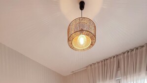Une chambre d’hôtel avec un grand lit, une lampe de chevet et une vue sur l’extérieur par la fenêtre.
