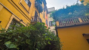 Un callejón estrecho entre edificios amarillos con balcones y ventanas.