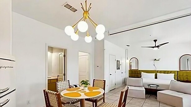 Un salon moderne avec un coin repas, des murs blancs et un ventilateur de plafond.