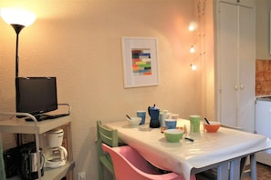 A small dining area with a table set for two, a television on a stand, and a coffee maker. - 10m from resort center, 3rd floor, tv, ski locker, 18m², Vars (Vars)
