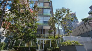 A modern building with a glass facade and a central entrance. - Studio with Pool and Garage – 7 min from Allianz (São Paulo)