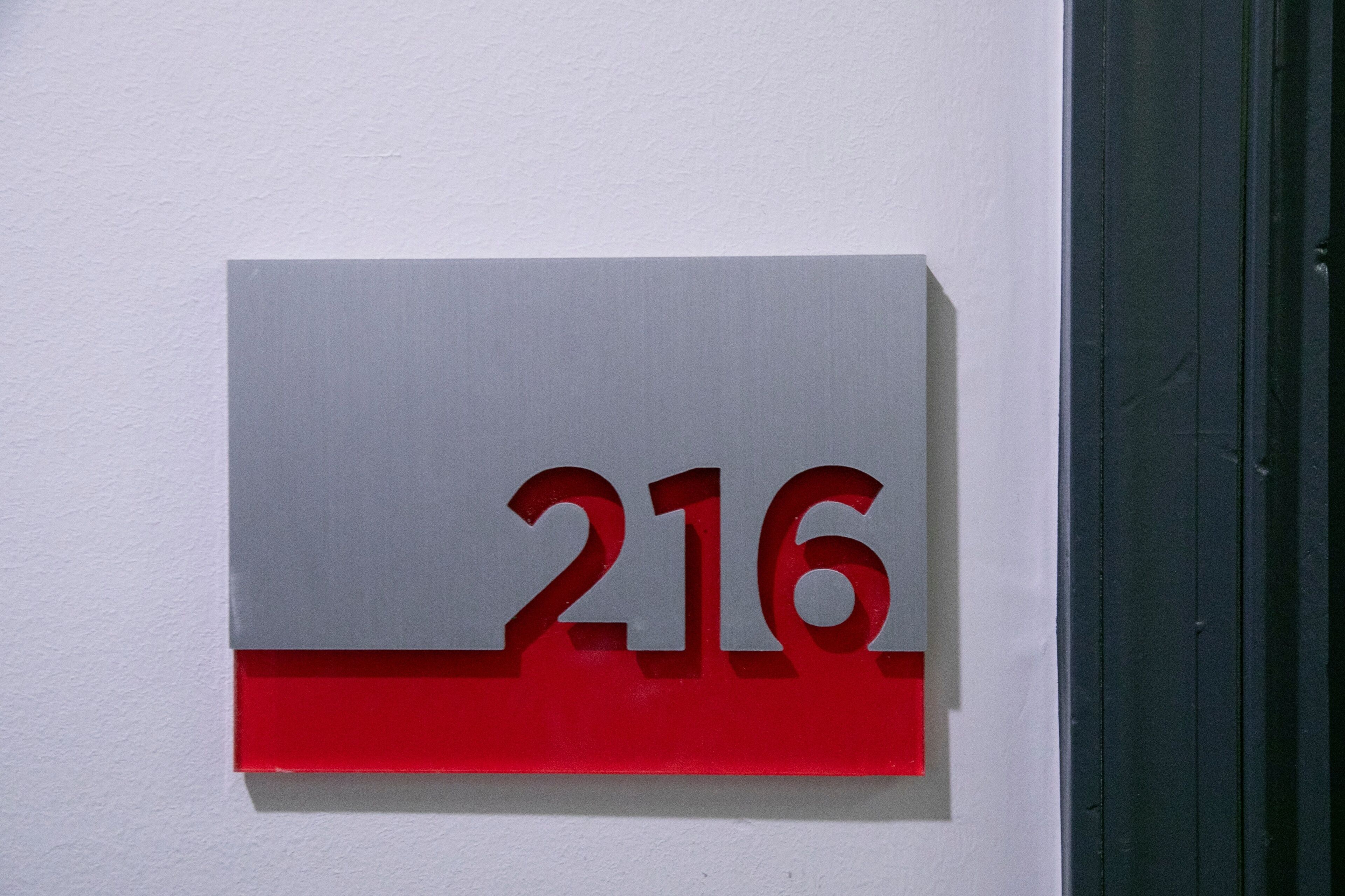 Ein an der Wand befestigtes Schild mit der Nummer 216.