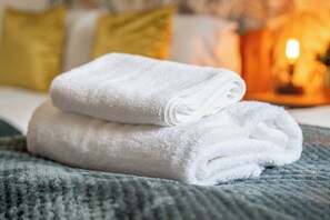 A neatly folded white towel stacked on top of another on a textured surface. - 3 Bed Flat - Sleeps 8 - Parking - Wifi (Birmingham)