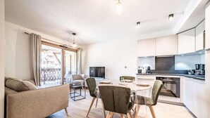 A modern apartment with a dining area, kitchen, and living room. - 140m from ski lifts, 1st floor, balcony, tv, 33m², Morzine (Morzine)