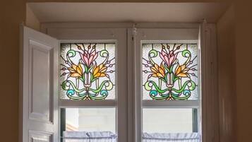 Una habitación con dos ventanas decoradas con vidrieras.