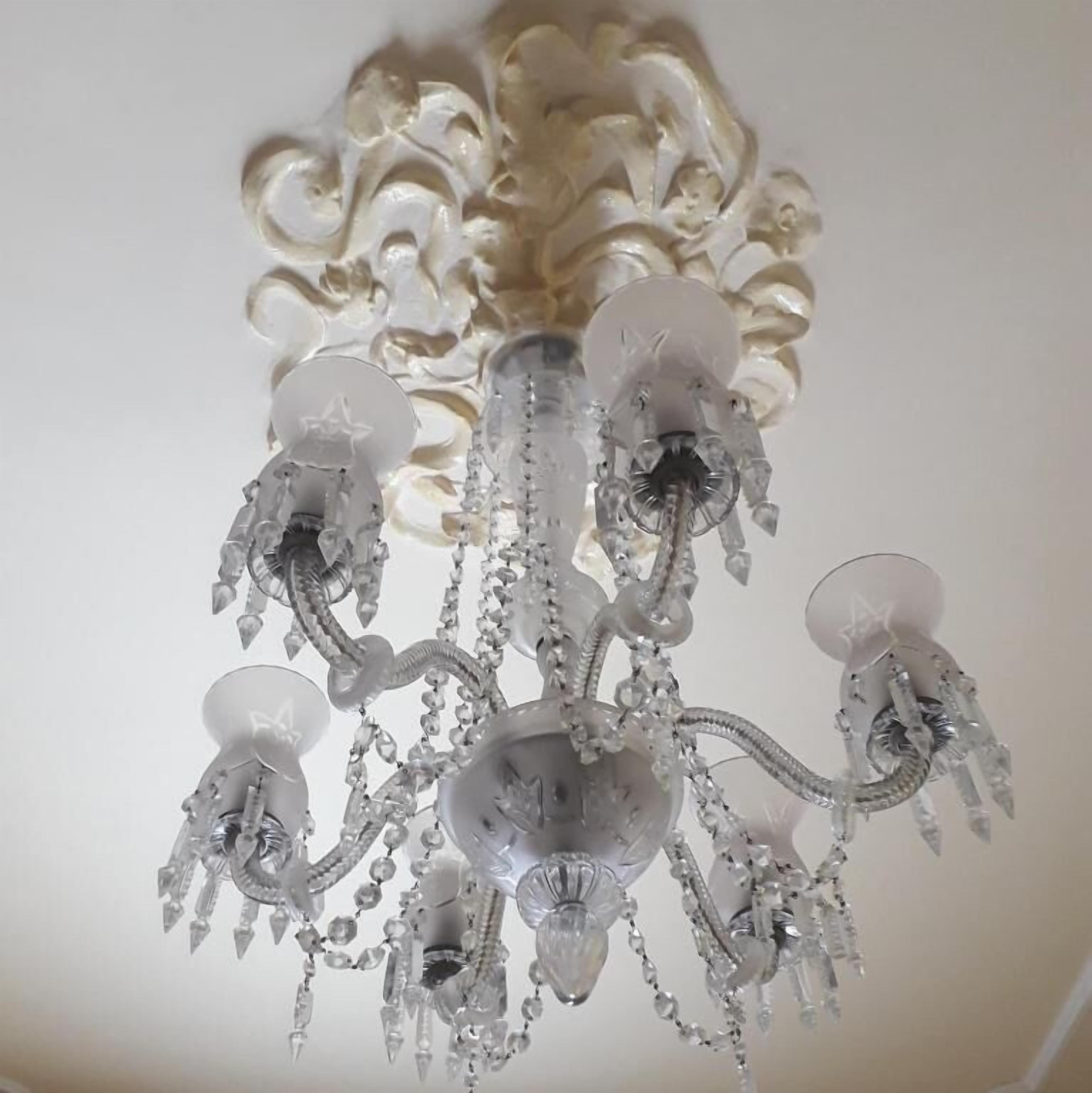 A chandelier with multiple arms and crystal decorations.