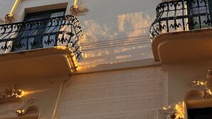 A building facade with ornate architectural details, including decorative moldings and a patterned ceiling. - Hotel Noucentista (Sitges)