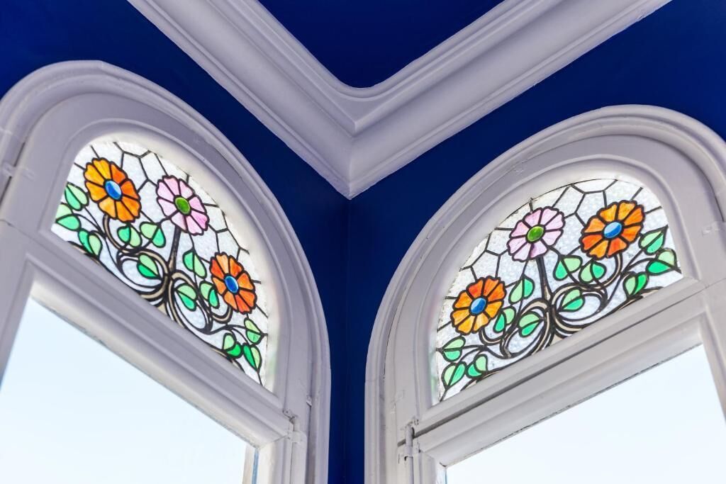 Twee glas-in-loodramen met bloemmotieven.