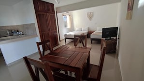 A compact living space with a kitchenette, a dining area, a bed, and a television. - Casa Calendario Azteca (Playa del Carmen)