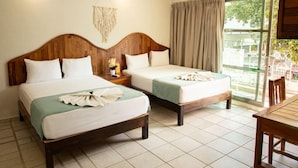 A hotel room with two wooden beds, a ceiling fan, a large window with curtains, and a view of the outside. - Casa Calendario Azteca (Playa del Carmen)