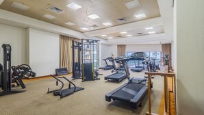 A gym with treadmills, weight machines, and a rowing machine. - Estúdio Moderno com Vista Mar em Recife BCI1603 (Recife)