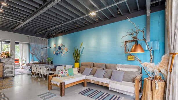 A modern living room with a blue accent wall, a sofa, a coffee table, and a dining area with chairs and a table. - House Near the Beach and Beto Carrero Efp0356 (Penha)