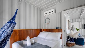 A hotel room with a bed, a hanging hammock, an air conditioning unit, and a doorway leading to another room. - House Near the Beach and Beto Carrero Efp0356 (Penha)