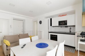 Una cocina moderna con armarios blancos, un reloj y un cartel que dice 'Cocktail'.