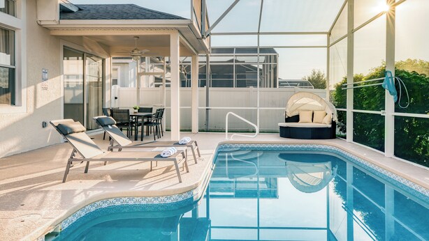 A swimming pool with lounge chairs and a covered seating area. - Stunning 4-Bed, 3-Bath Pool Home – Just Minutes from Orlando’s Theme Parks (Davenport)