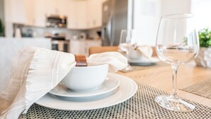 A dining table with a white bowl and a wine glass, set on a woven placemat. - Stunning 4-Bed, 3-Bath Pool Home – Just Minutes from Orlando’s Theme Parks (Davenport)