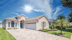 A single-story house with a garage, a driveway, and a well-maintained lawn. - Stunning 4-Bed, 3-Bath Pool Home – Just Minutes from Orlando’s Theme Parks (Davenport)