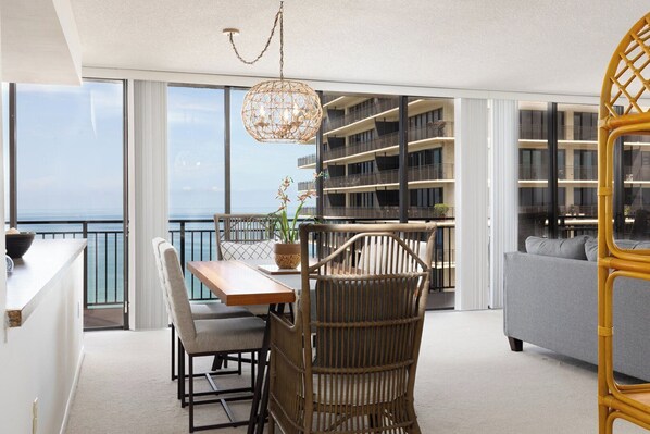 Un balcon aménagé avec un coin repas, un canapé et une bibliothèque.