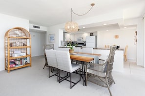 A modern kitchen with white cabinets, a microwave, and a refrigerator.