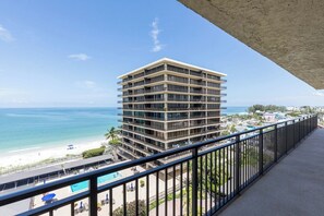 Un hôtel de grande hauteur doté de nombreux balcons offrant une vue sur une plage et l’océan.