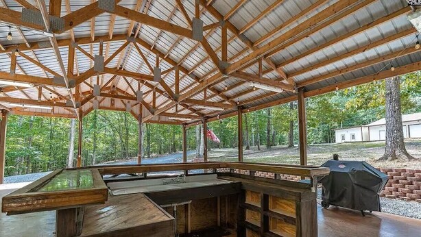 A covered outdoor area with a wooden bar and grill.