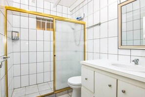 Een douche, handdoeken, zeep, toiletpapier