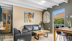 Ein modernes Wohnzimmer mit Sofa, Couchtisch und Essbereich.