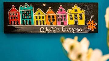 Ein farbenfrohes Schild mit dem Schriftzug 'City Life Curacao' und einer Blume.