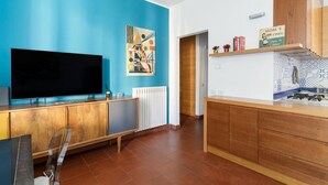 Una cocina moderna con un televisor de pantalla plana, armarios de madera, una pared de acento azul y un letrero que dice 'Mom's Line'.