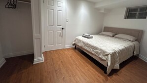Quarto com cama, porta e janela.