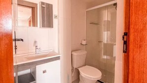 Un baño con inodoro, lavamanos y ducha.