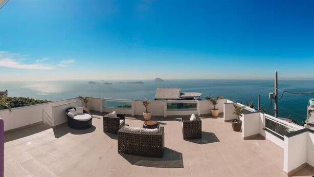 Terraza en la azotea con mobiliario exterior, piscina y vistas al mar.
