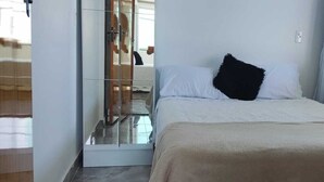 Habitación de hotel con cama, espejo, ventana y una planta.