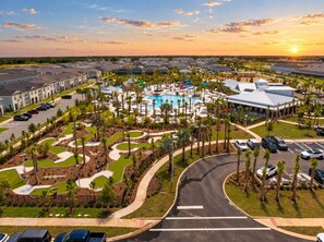 Un complexe hôtelier doté d’une piscine, de palmiers et d’un parking.