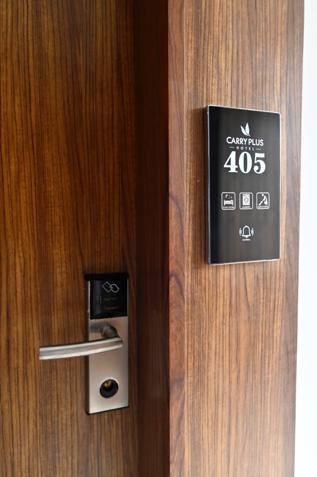 Porta d'una habitació d'hotel amb un tancament digital i un senyalitzador amb el número 405.