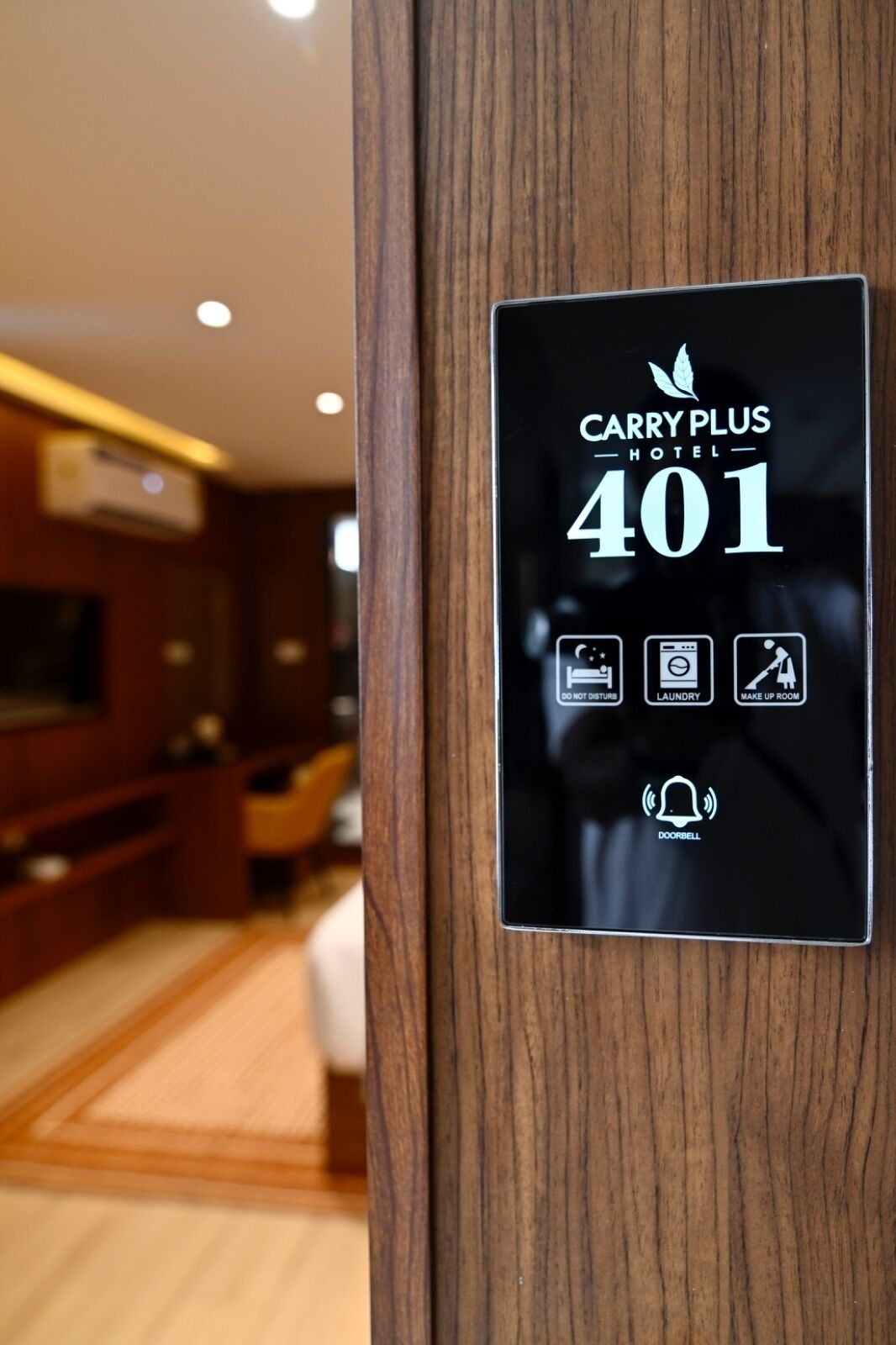 A hotel room door with a sign indicating room number 401 and icons for amenities like a bed, laundry, and a make-up room.