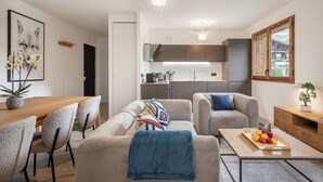 A modern living room with a sofa, coffee table, and dining area.