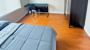 Una camera da letto con un letto, una scrivania e un armadio.