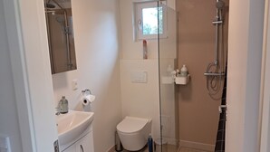 Un baño con inodoro, lavabo y ducha.