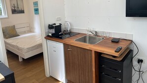 A compact kitchenette with a coffee maker, kettle, and sink. - Office/apartment combo Rothschild Blv in TelAviv! Parking, elevator, shelter (Tel Aviv-Yafo)