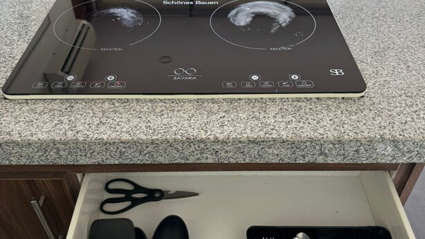 A kitchen with a modern induction cooktop and a drawer with neatly arranged utensils. - Escapada junto al mar en B Nayar (Cruz de Huanacaxtle)