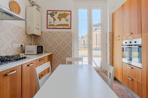 Cocina con estufa a gas, microondas, horno y armarios de madera.
