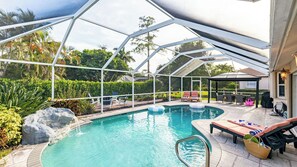 A covered swimming pool with lounge chairs and a pergola. - Private Pool, Firepit, Game Room Mins to Beaches + Community Amenities Casa Solara by Avantstay (Naples)