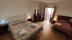 A bedroom with a bed, a dresser, a mirror, and a door leading to a balcony. - Apartment in Farmhouse with 2 bedrooms and 2 bathrooms nestled in the Tuscan Maremma (Gavorrano)