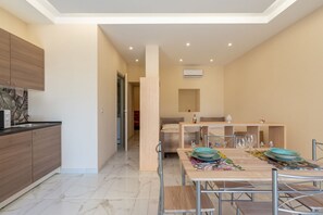 A modern kitchen with a dining area, a built-in oven, and a ceiling light fixture.