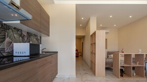 A modern kitchen with a microwave, wooden cabinets, and a patterned backsplash.
