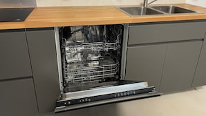 A kitchen with a built-in dishwasher, a wooden countertop, and a stainless steel sink. - Large Duplex Apartment 85m2 (Fleurieux-sur-l'Arbresle)