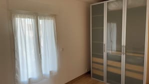 A room with a sliding glass door, a window with sheer curtains, and a wooden floor. - Large Duplex Apartment 85m2 (Fleurieux-sur-l'Arbresle)
