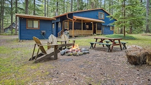 A cabin with a porch, a fire pit, and picnic tables. - Mt Hood Cabin Sanctuary with Hot Tub, Pets Welcome (Mount Hood Village)