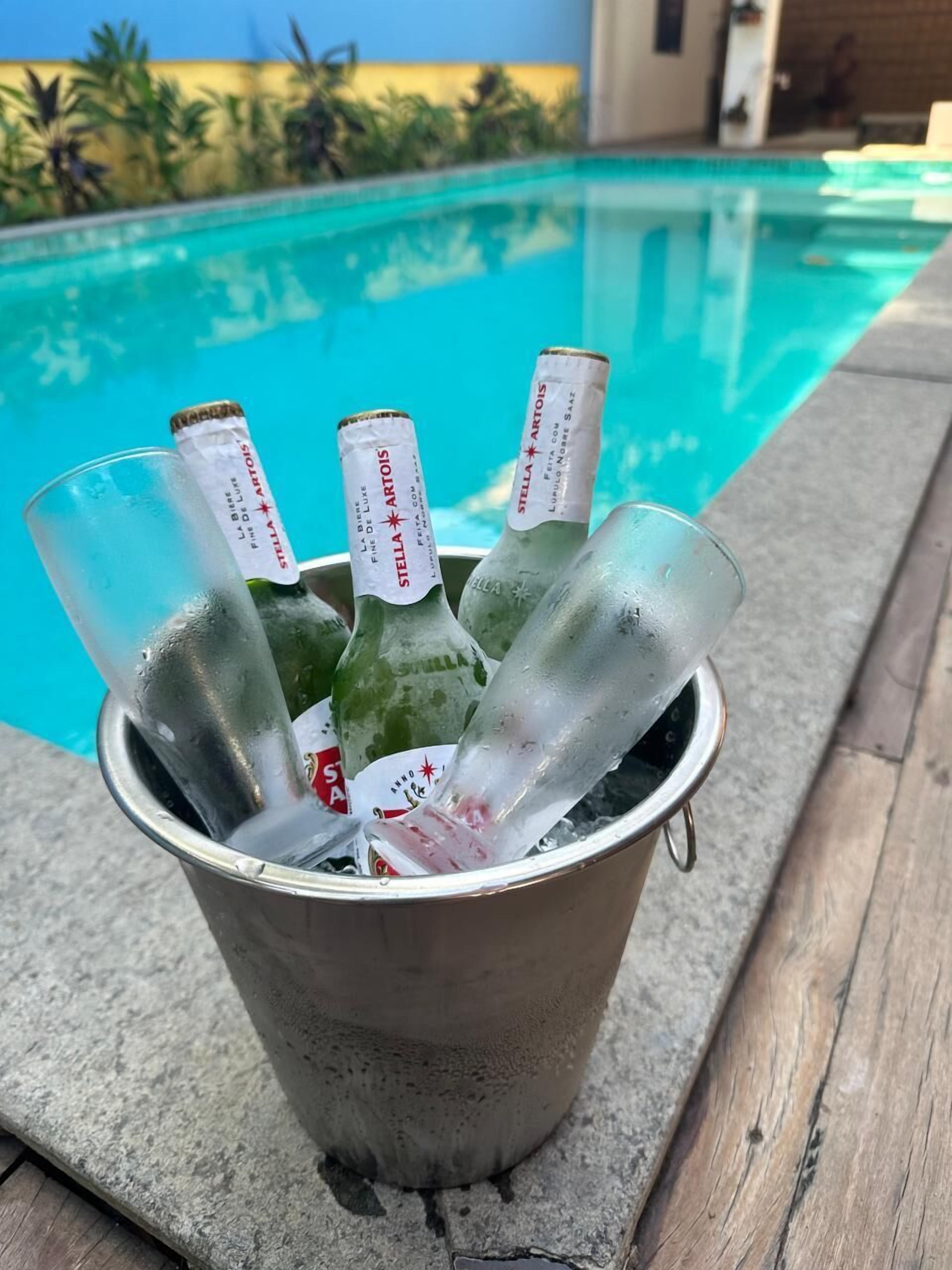 A bucket filled with ice and bottles of Stella Artois beer by the poolside.